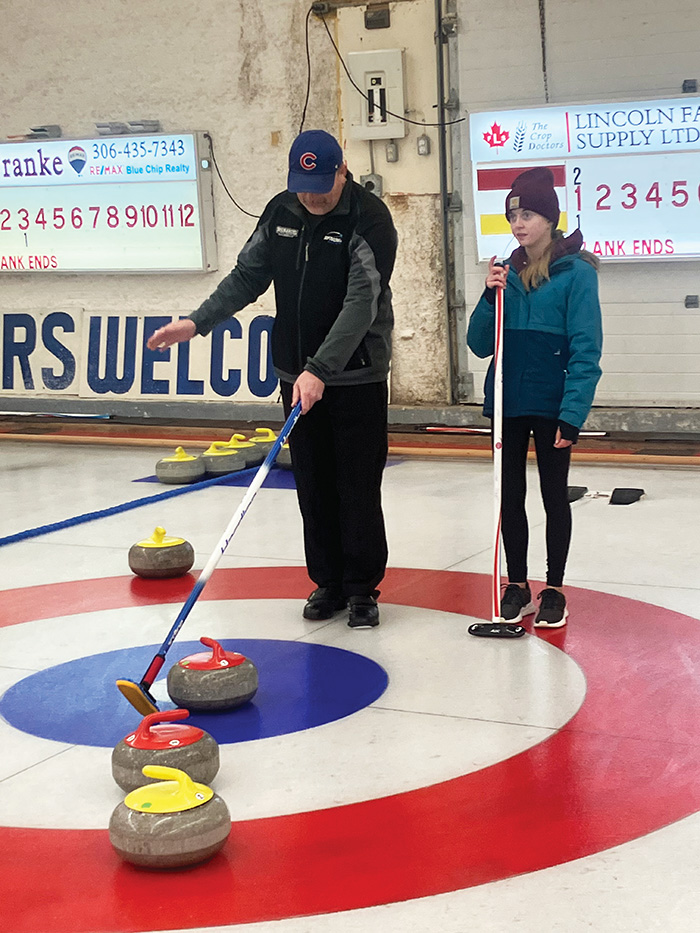 Cory Barkley helping coach a junior curler.”></a><br />
<p class=